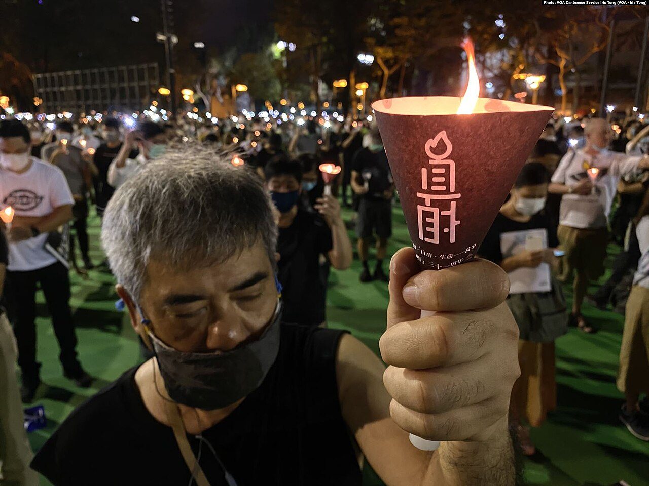 2020 年,港府以防疫为由首次禁止维园晚会,市民仍自发涌入,举起印有「真相」的烛光(美国之音摄)。此后主办者被捕、晚会