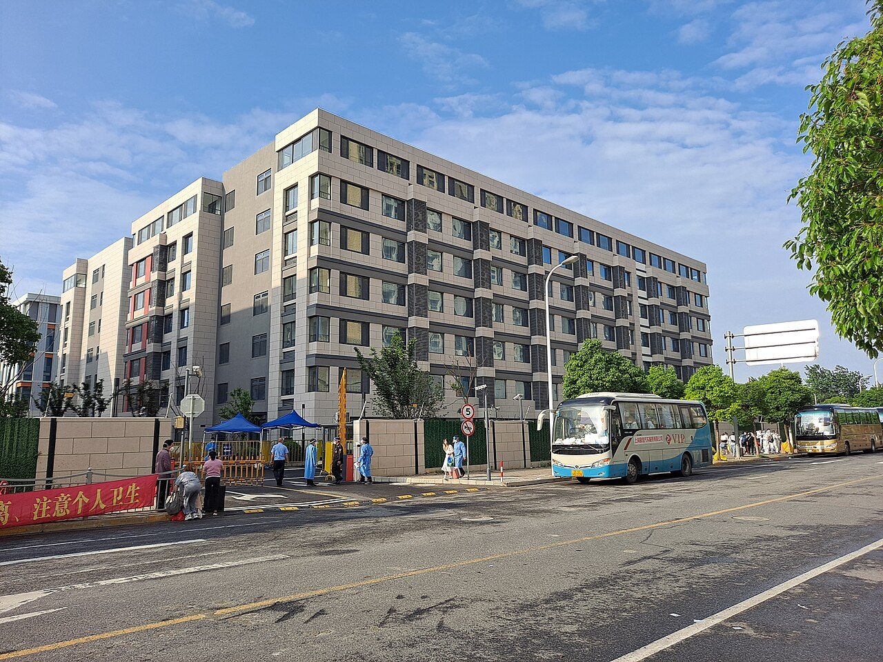 上海浦东合庆镇的集中隔离点:大巴成批转运居民,拖着行李箱的人走进被围起的楼宇。密接、次密接乃至整栋楼的住户,都可以这样被