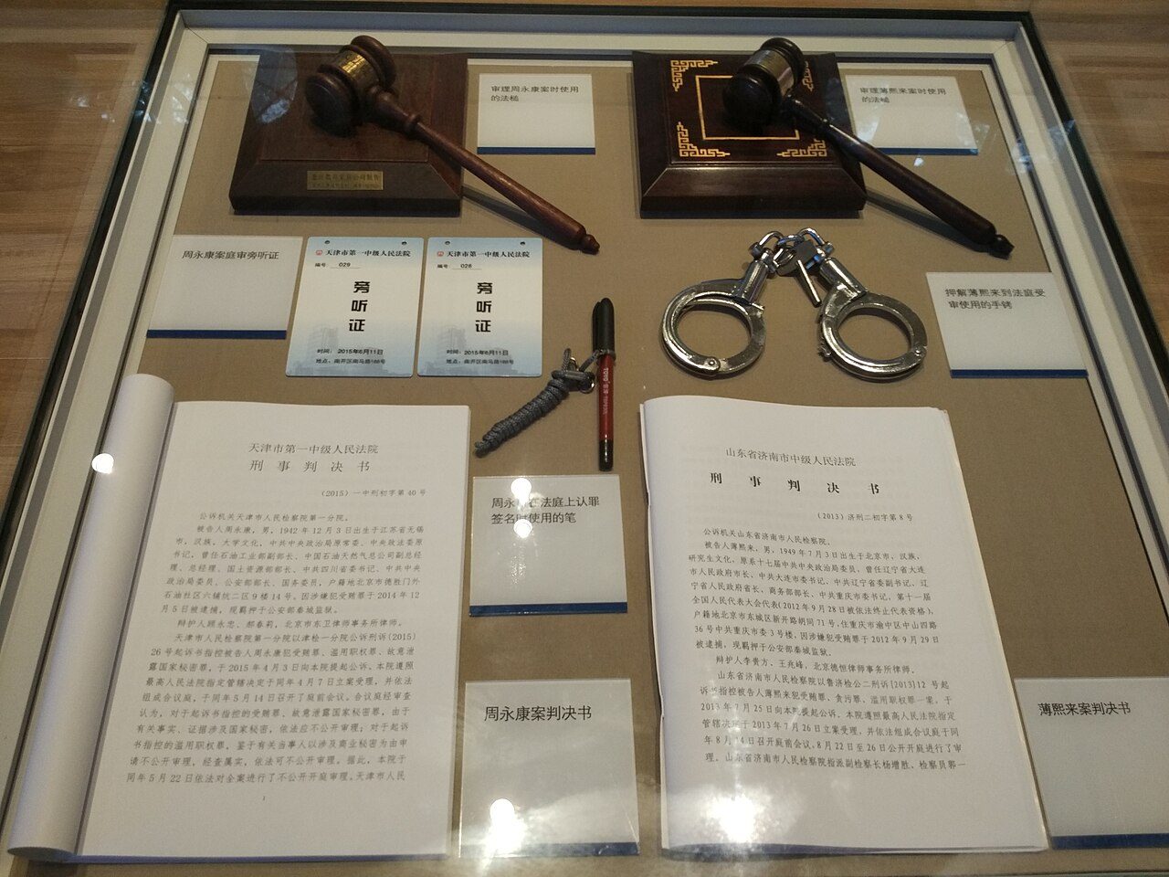 反腐展览的玻璃柜里,并排陈列着周永康案与薄熙来案的判决书、审案法槌与押解薄熙来时用的手铐。落马者被示众,产生他们的制度—